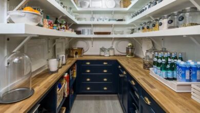 Small butler pantry with open shelves, wood counters, dark lower cabinets, and neatly arranged jars