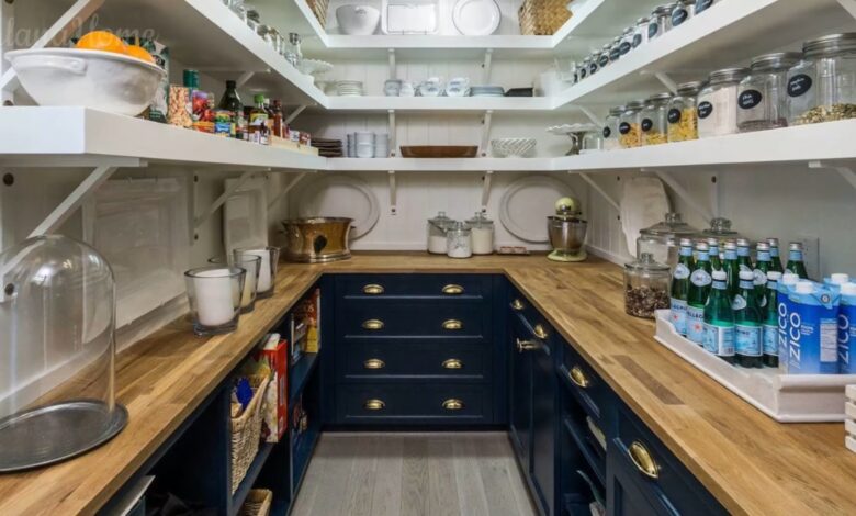 Small butler pantry with open shelves, wood counters, dark lower cabinets, and neatly arranged jars
