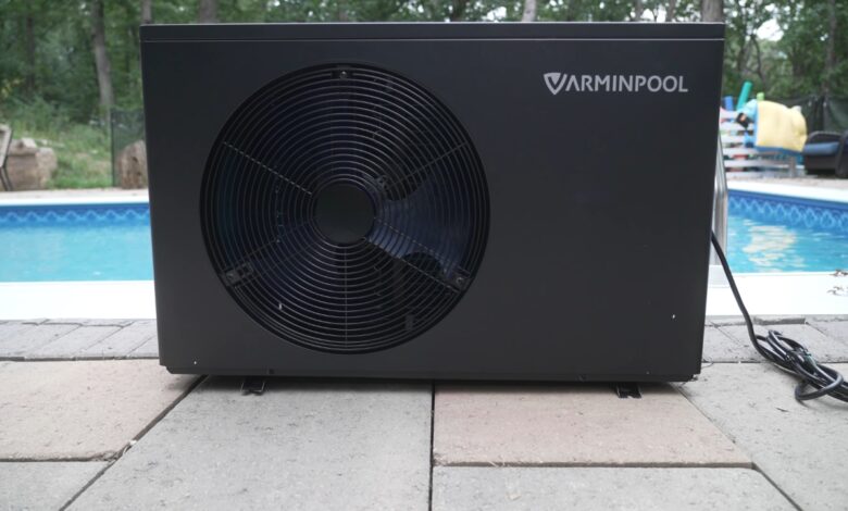 Black pool heat pump installed beside a backyard pool