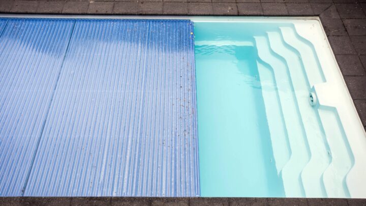 Small pool partly covered with a blue pool cover