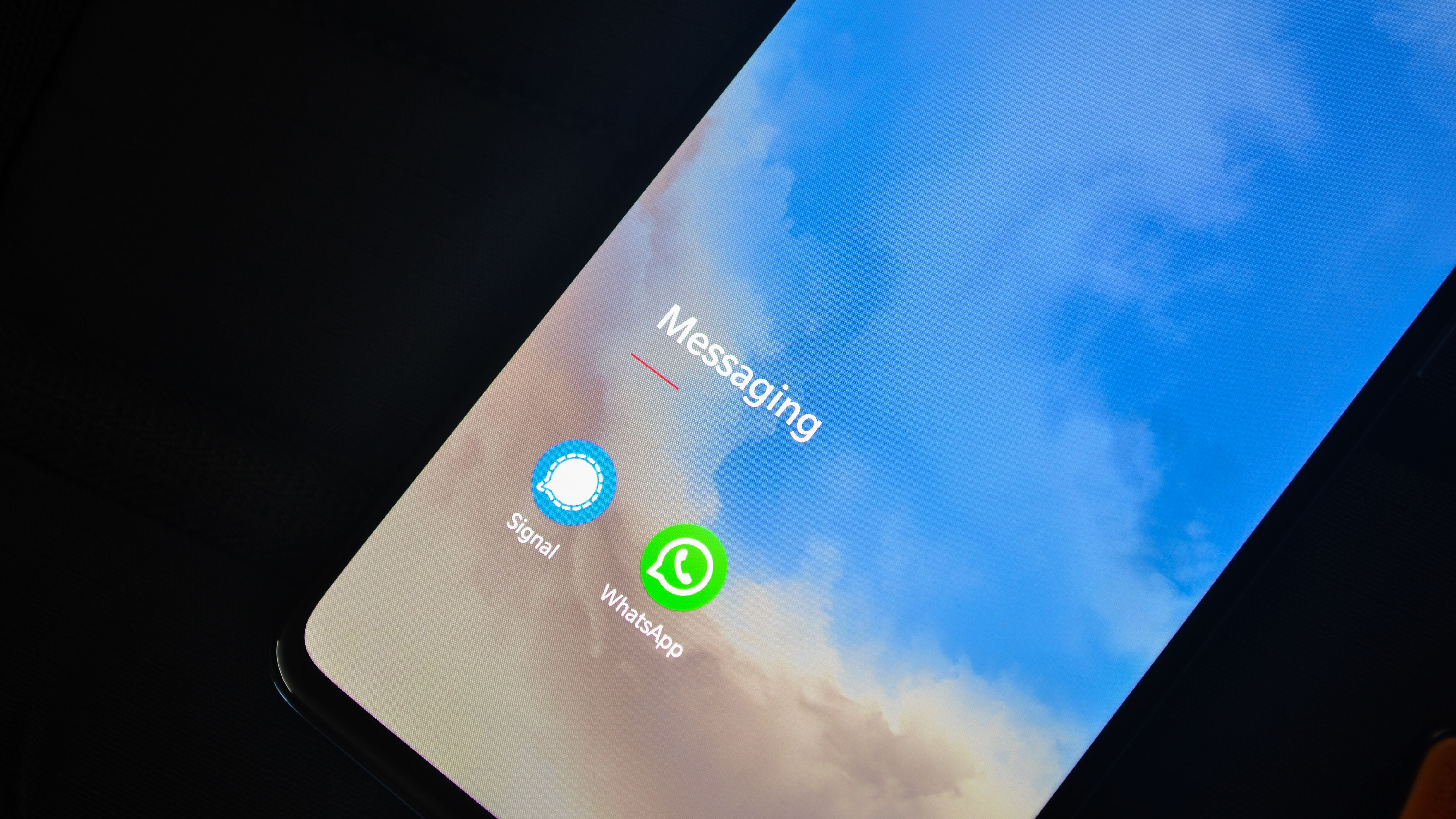 Close-up of a smartphone screen showing the Signal and WhatsApp encrypted messaging apps