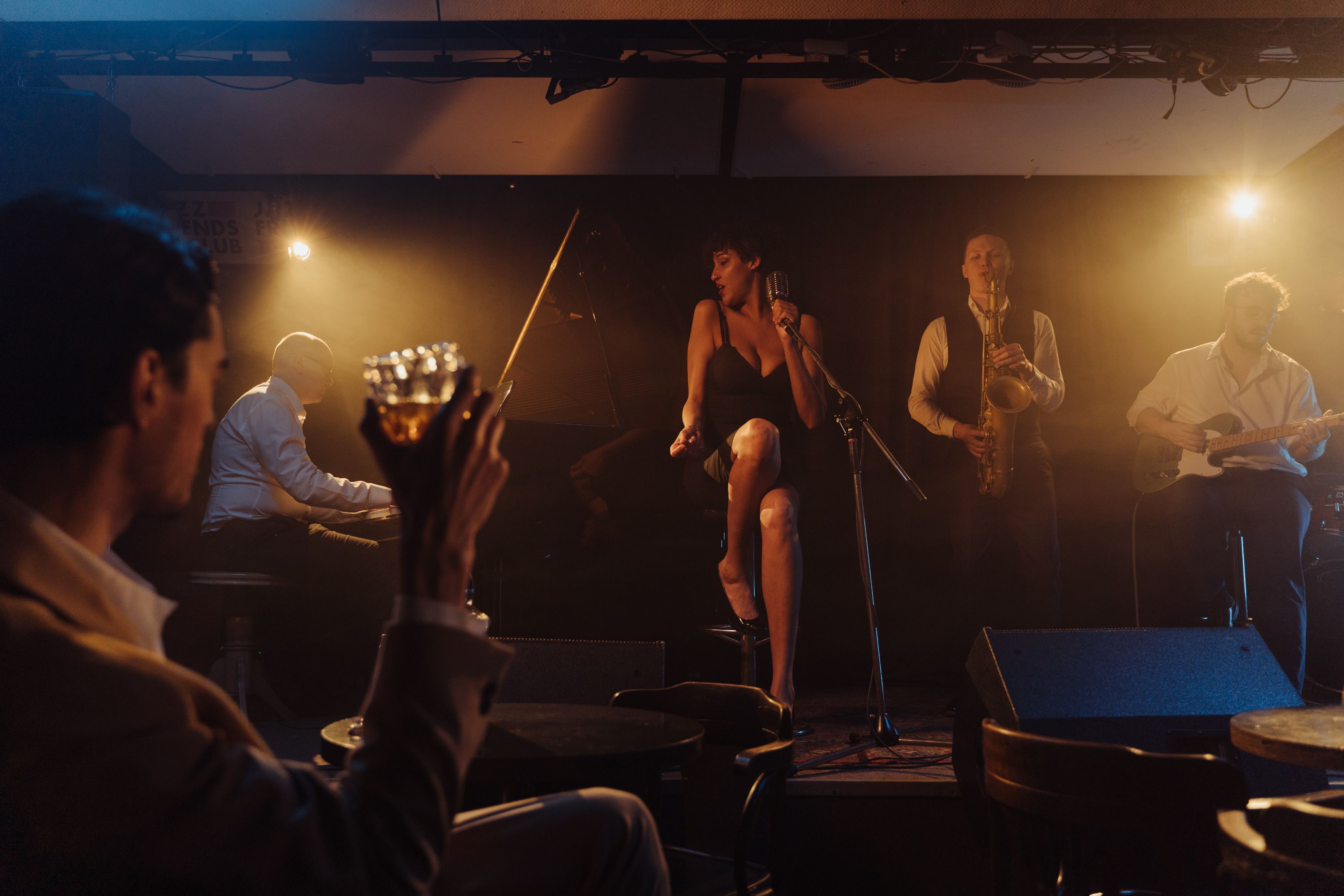 Jazz band performing live on stage with a singer in the cozy ambiance of a small local bar