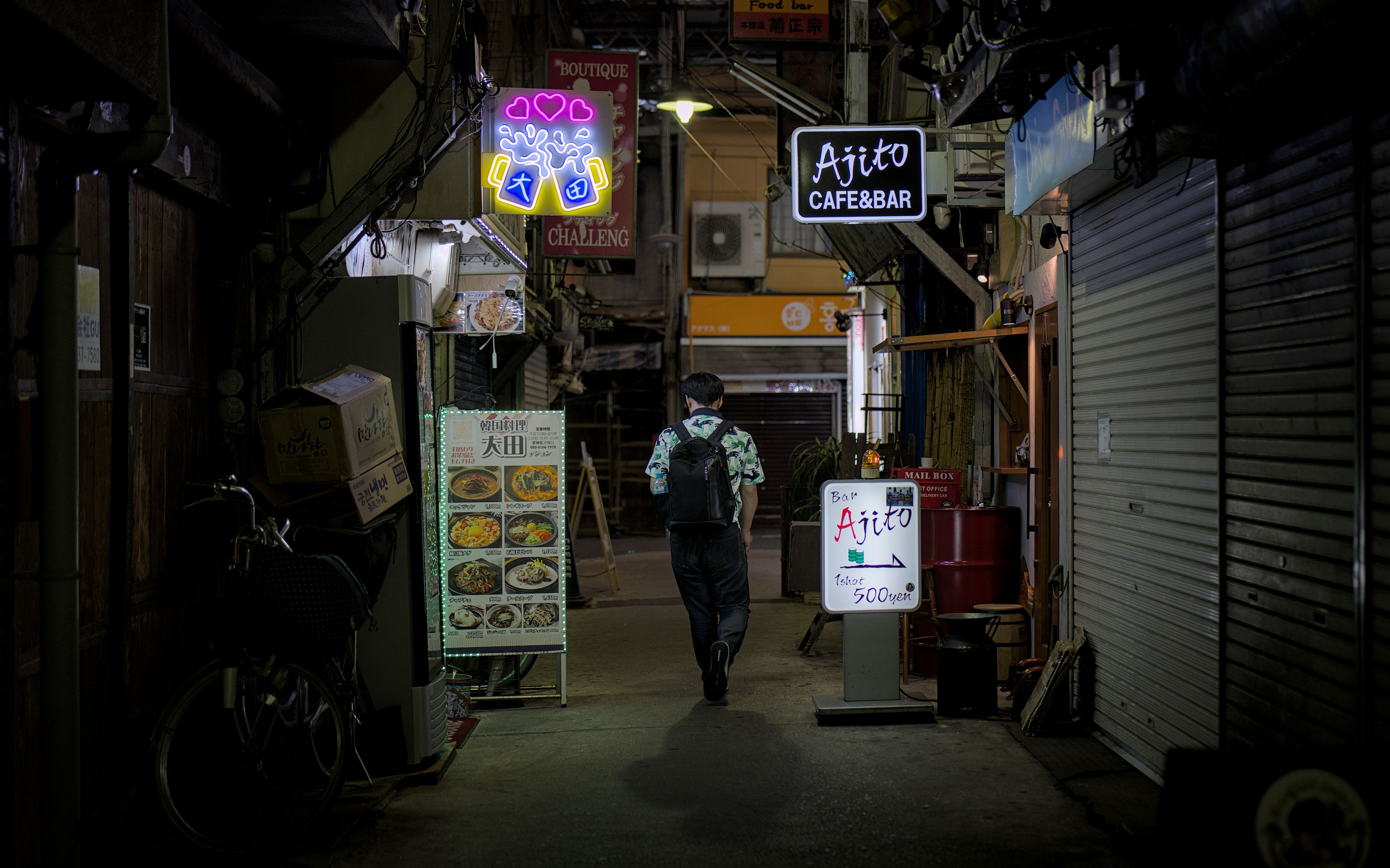 Narrow alley in Osaka filled with neon signs and tiny eateries, a hidden spot beyond tourist streets